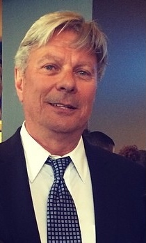 A man in suit and tie smiling for the camera.