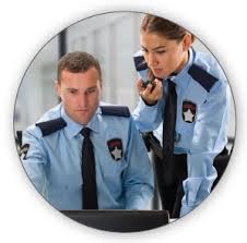 A man and woman in uniform looking at a laptop.