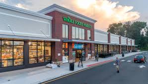 A whole foods market store on the side of a street.