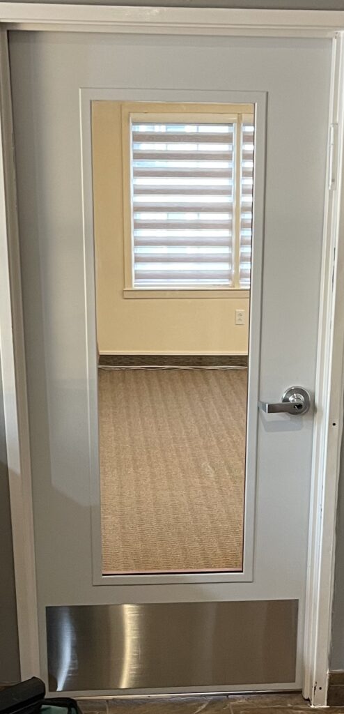 A hallway with a door open and a doorway in the background.